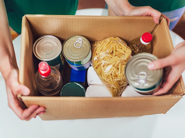 Cardboard box containing food tins and packages - food bank donation